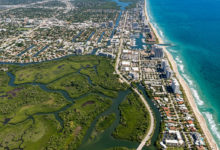 Aerial view of a coastal city bordered by wetlands and the ocean with buildings and waterways